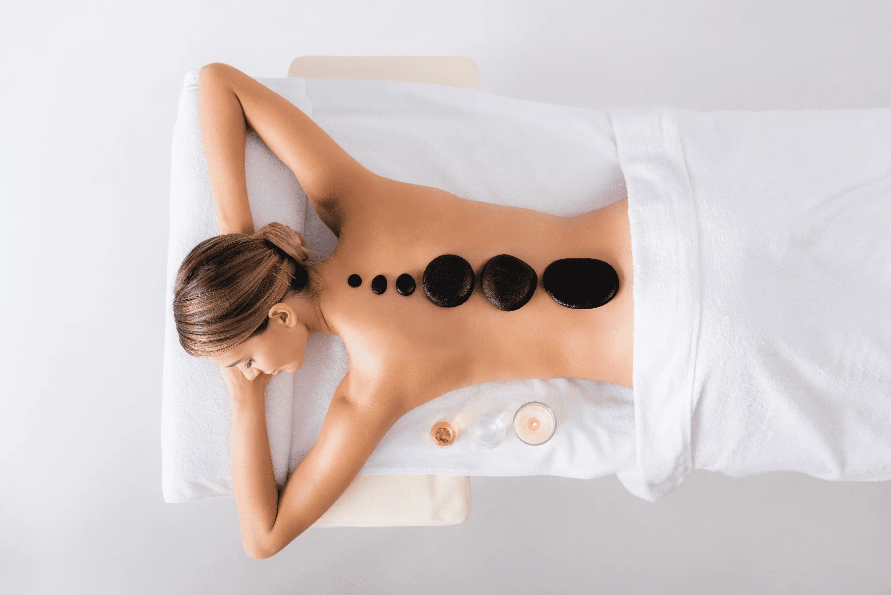 Masaje de relajación con piedras calientes en un entorno de spa.